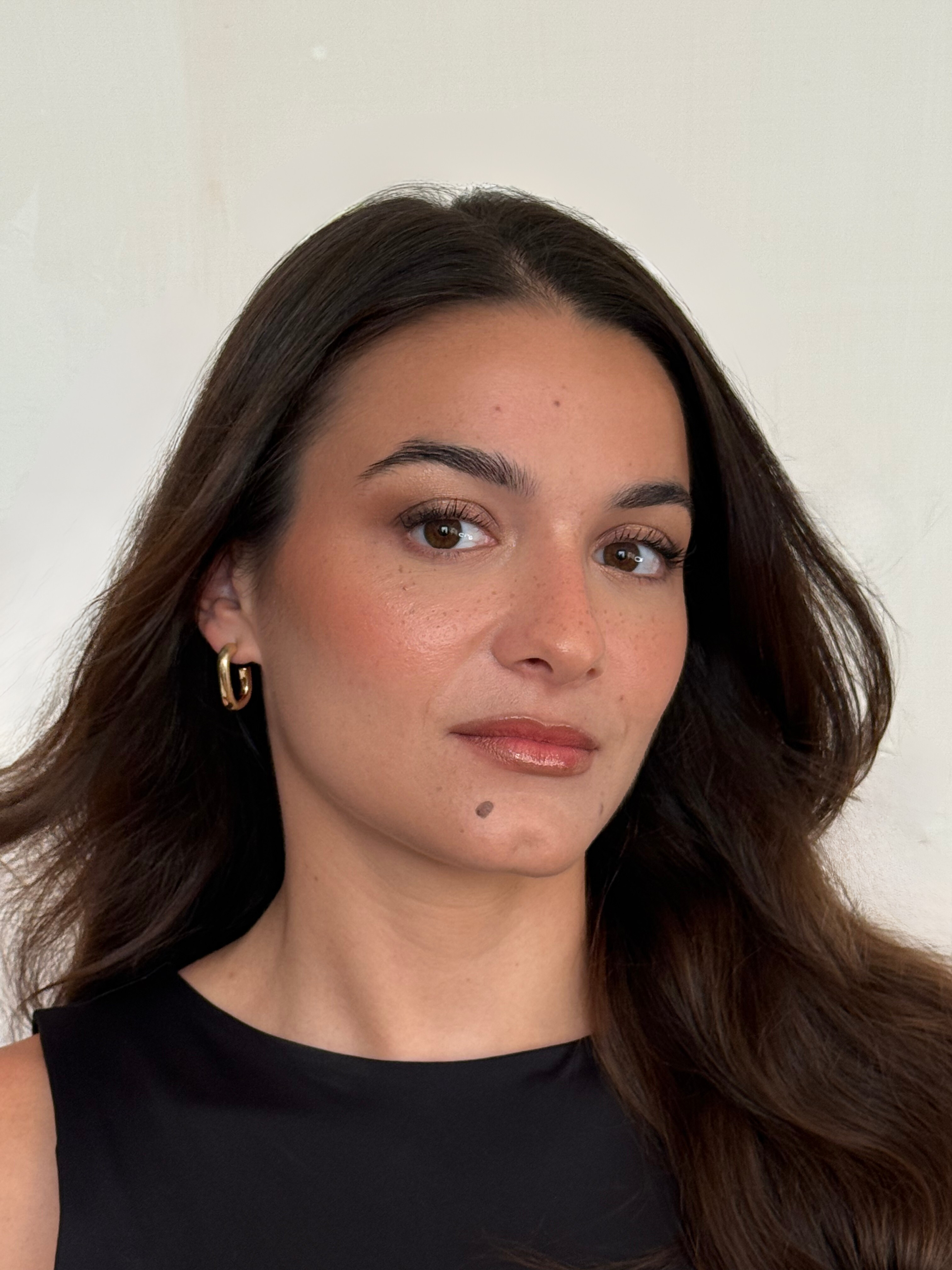 A luminous soft nude glam look featuring radiant skin, subtly defined eyes, and glossy nude lips for a naturally elegant finish.